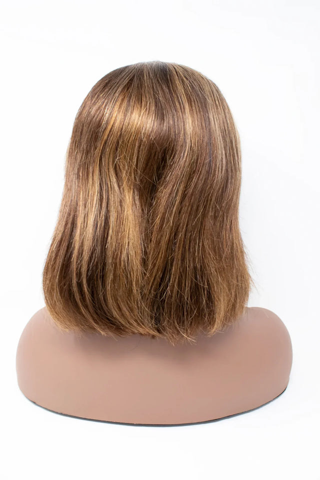 Natural human hair wig with layered bob cut, showcasing smooth texture and warm brown tones on mannequin.
