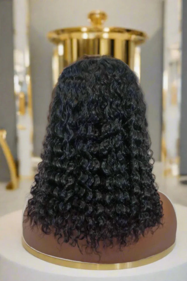 Luxury human hair wig with deep curls displayed on mannequin head, premium quality for natural styling