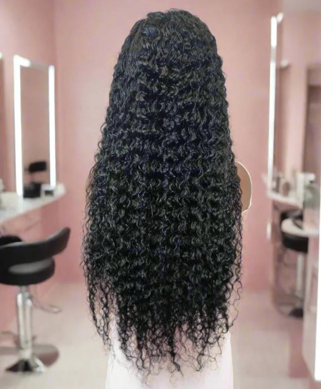 Long curly human hair wig with natural volume, styled in a salon setting for versatile beauty looks.