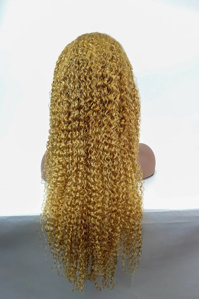 Golden curly human hair wig with voluminous waves, displayed on mannequin for natural styling