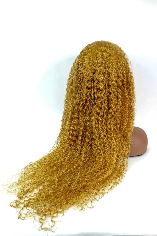 Golden curly human hair wig on mannequin head, natural styling for versatile beauty looks