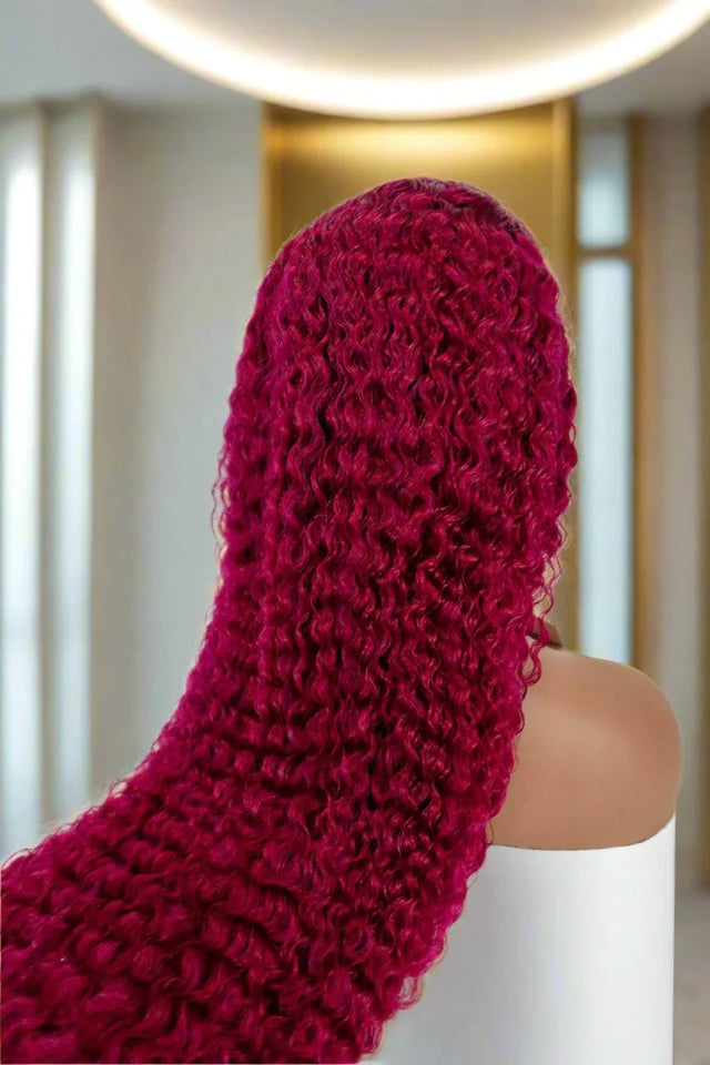Vibrant burgundy curly human hair wig on mannequin, showcasing natural texture and volume for stylish looks