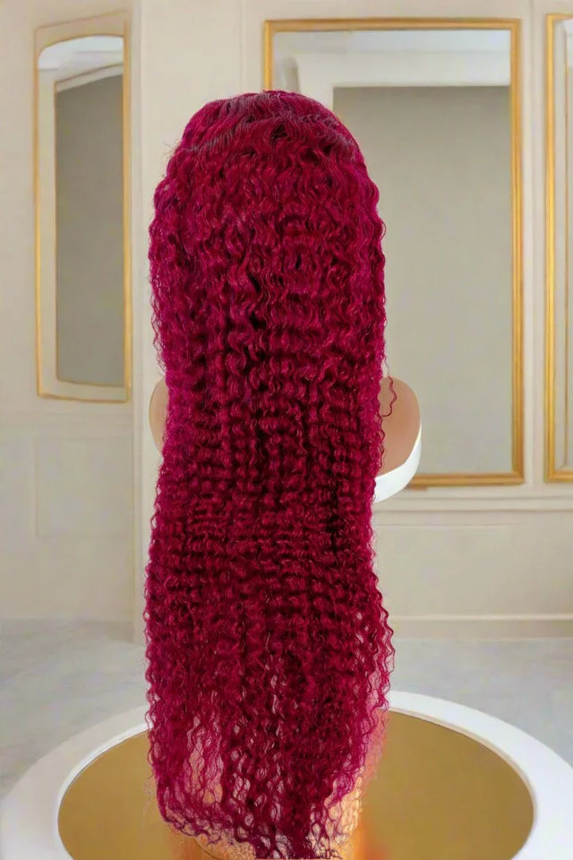 Vibrant burgundy curly human hair wig on mannequin, luxury styling for natural looks