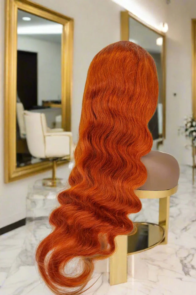 Vibrant red human hair wig with loose waves displayed on mannequin in salon setting