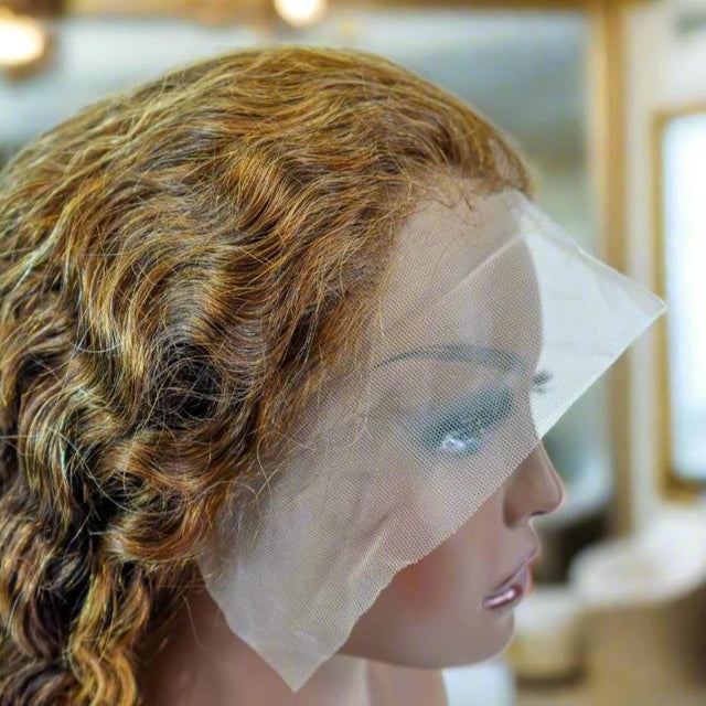 Curly human hair wig with lace front on mannequin, natural styling ready