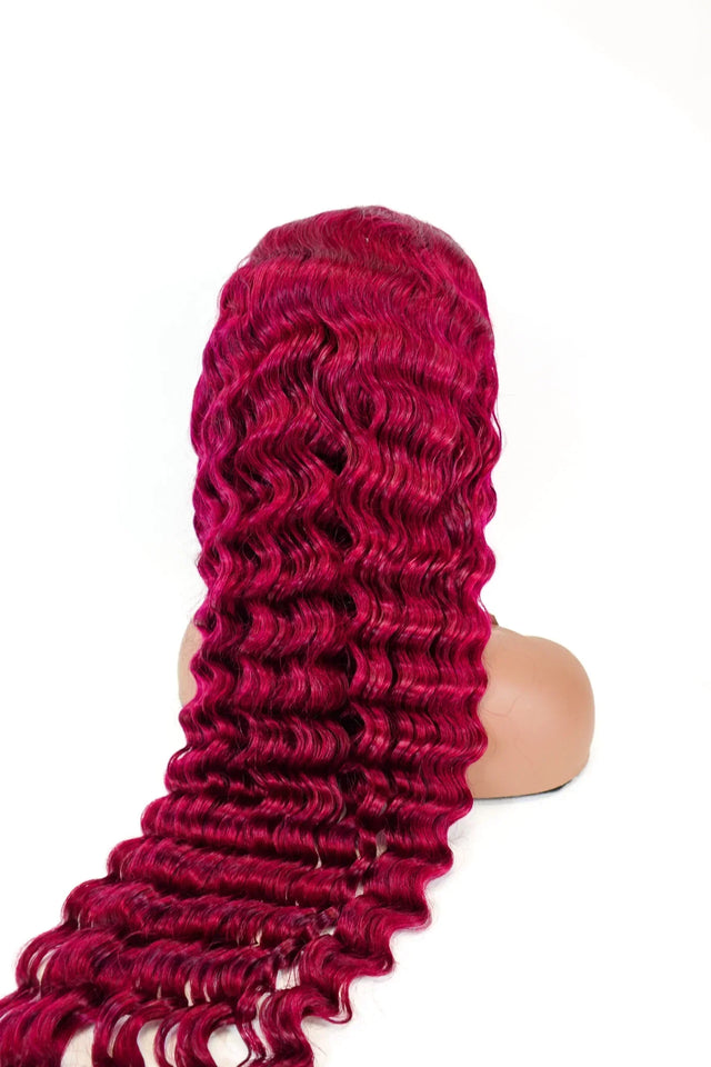 Vibrant red curly human hair wig on mannequin, long wavy texture for natural styling