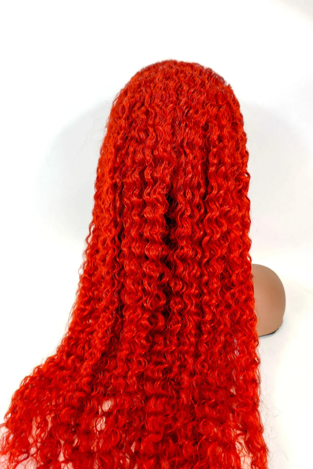 Vibrant red curly human hair wig on mannequin head, natural styling ready