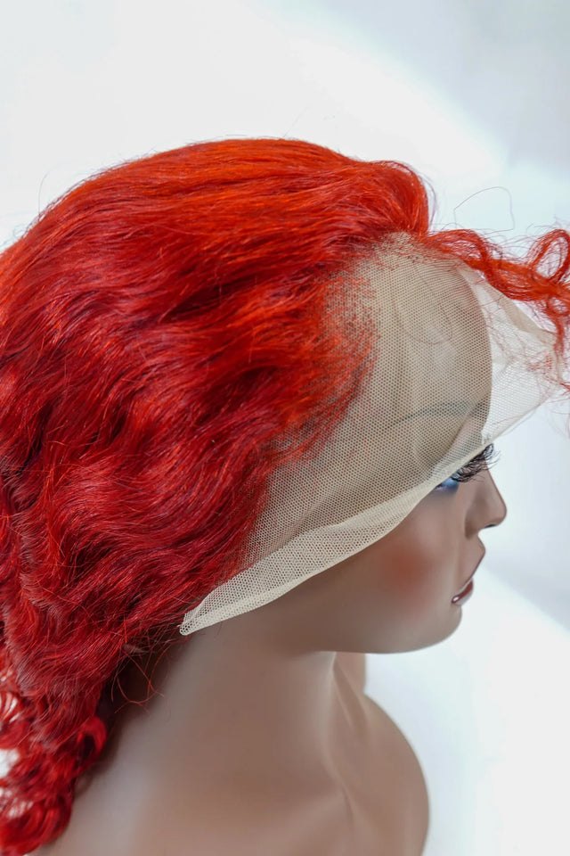 Vibrant red human hair lace front wig with natural waves on mannequin