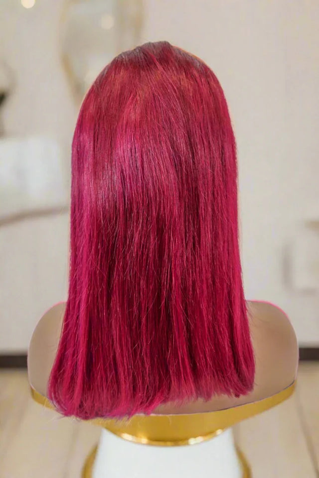 Vibrant red human hair wig on mannequin, sleek straight style for natural look