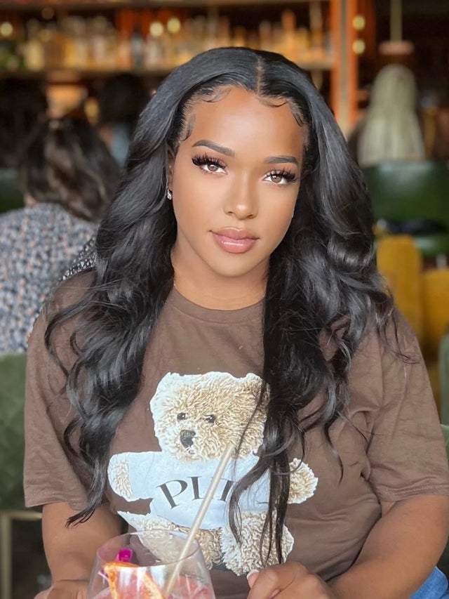 Woman with long wavy black human hair wig, natural styling, in cafe setting