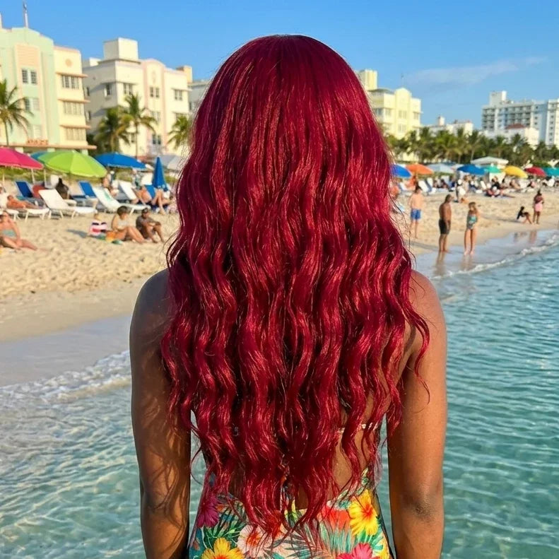 Person with red hair wearing a colorful swimsuit on a beach