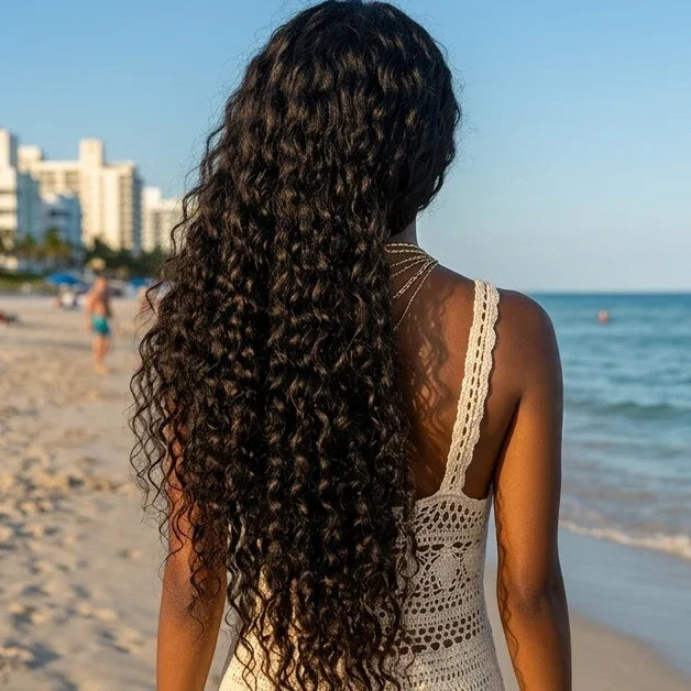 Woman with long curly human hair wig at beach, natural styling for summer