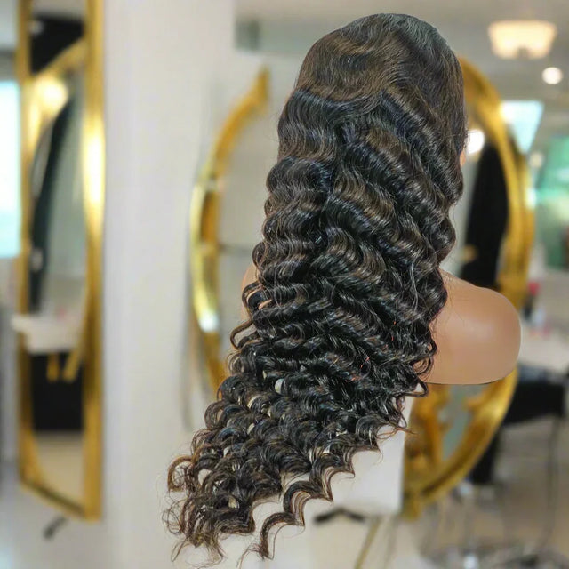 Deep wave human hair wig on mannequin, salon setting with gold mirrors