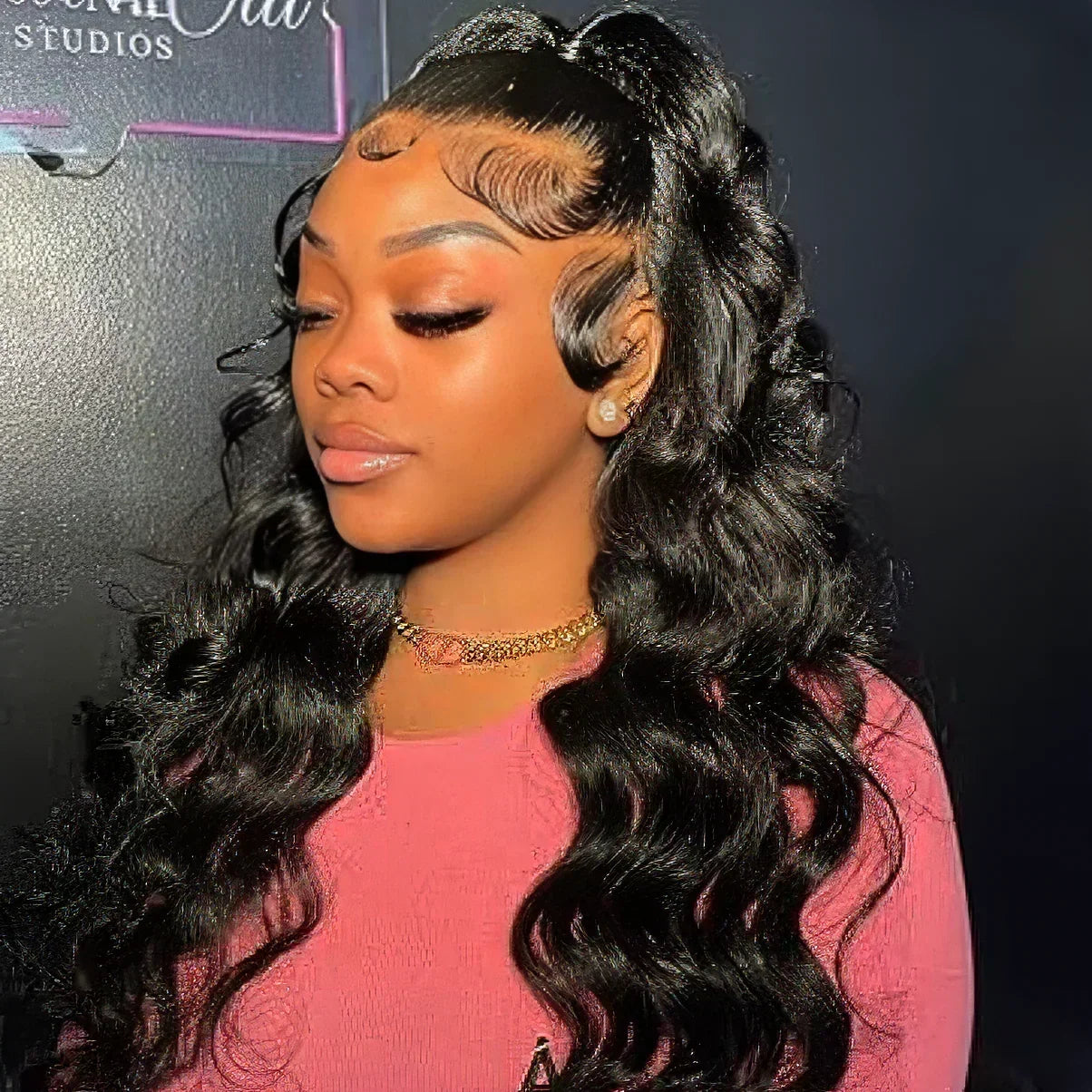 Black woman wearing a human hair wig with deep waves and natural-looking baby hairs, styled in a high ponytail.