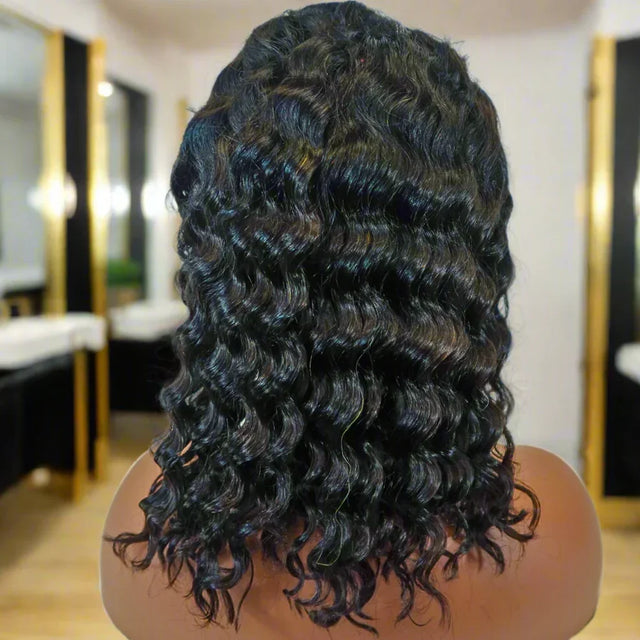 Deep curly human hair wig with natural waves, shown from back in salon setting