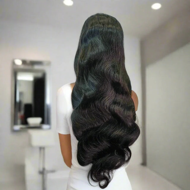 Long wavy human hair wig with natural body waves, styled for voluminous look in salon setting