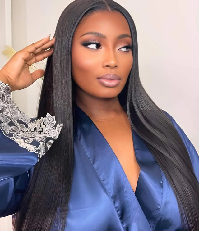 Woman wearing sleek human hair wig, styling long straight hair in blue robe