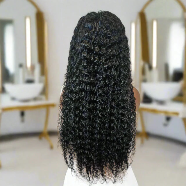 Long curly human hair wig with natural volume, shown from back in salon setting