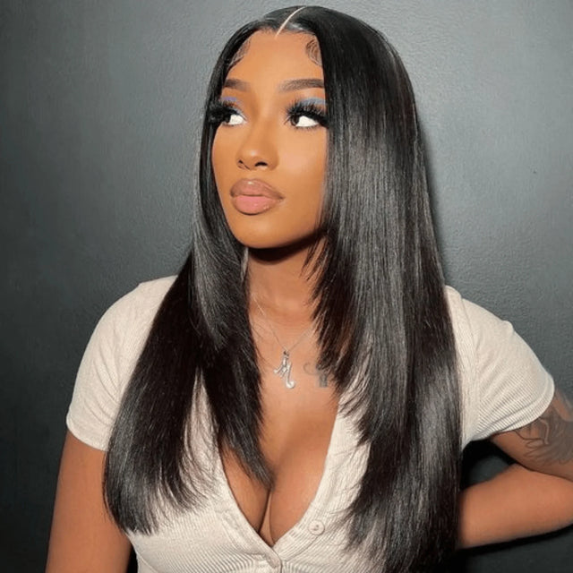 Woman wearing sleek black human hair wig with lace front, styled straight for natural look