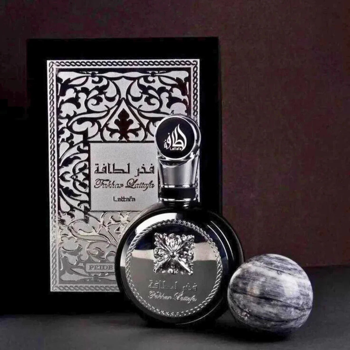 Luxury Fakhar Lattafa perfume bottle with ornate silver packaging and marble sphere, elegant fragrance gift set