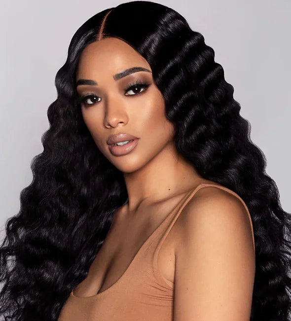 Woman wearing long, deep wave human hair wig with natural part, styled for voluminous, glossy look