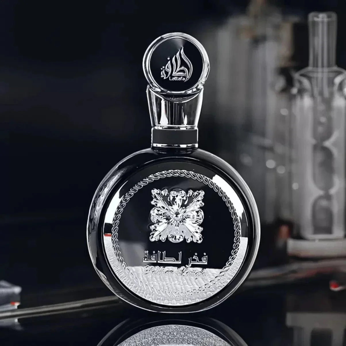 Luxury black perfume bottle with silver floral design and Arabic script, elegant fragrance packaging
