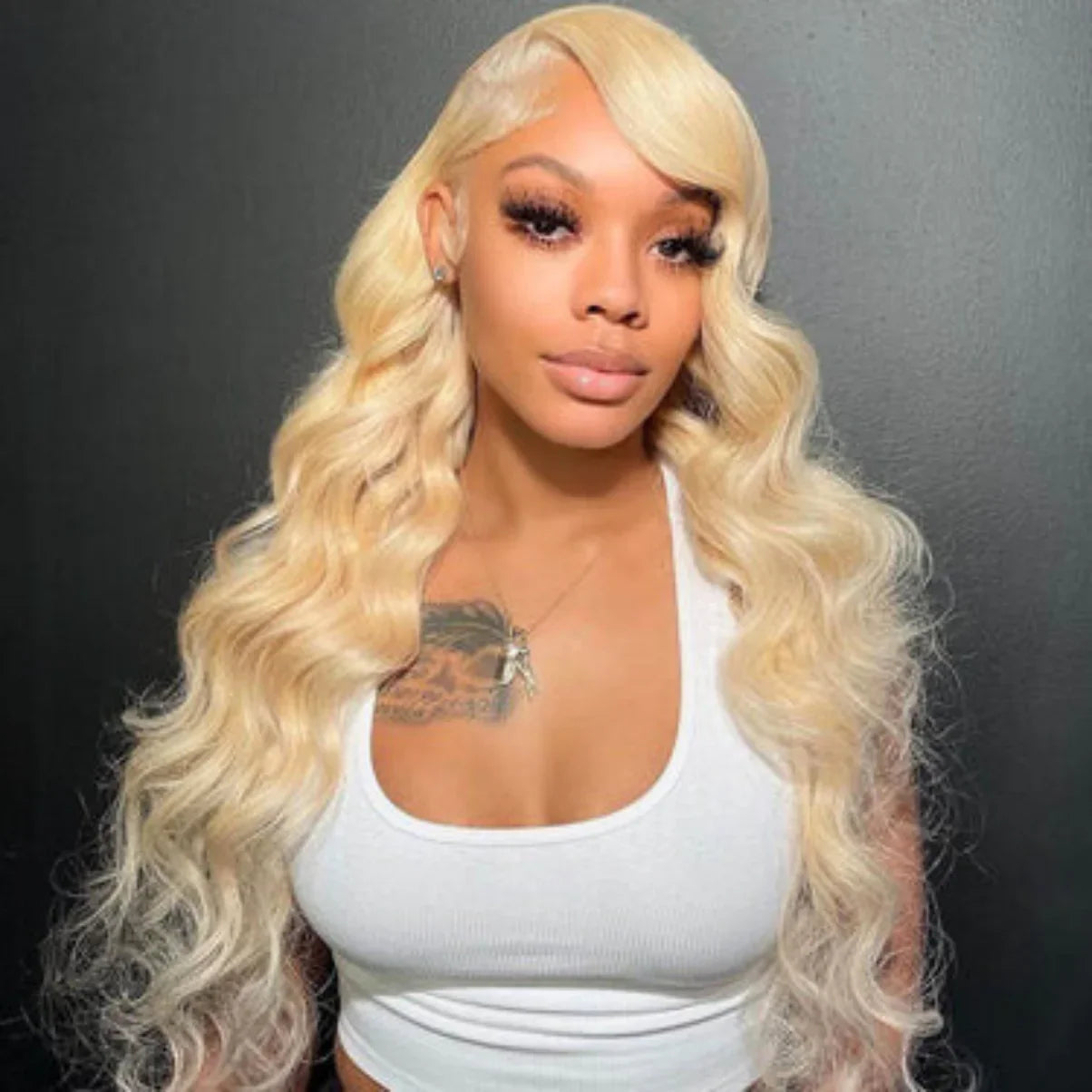 Blonde human hair wig with voluminous body waves, natural-looking lace front, styled for everyday wear.