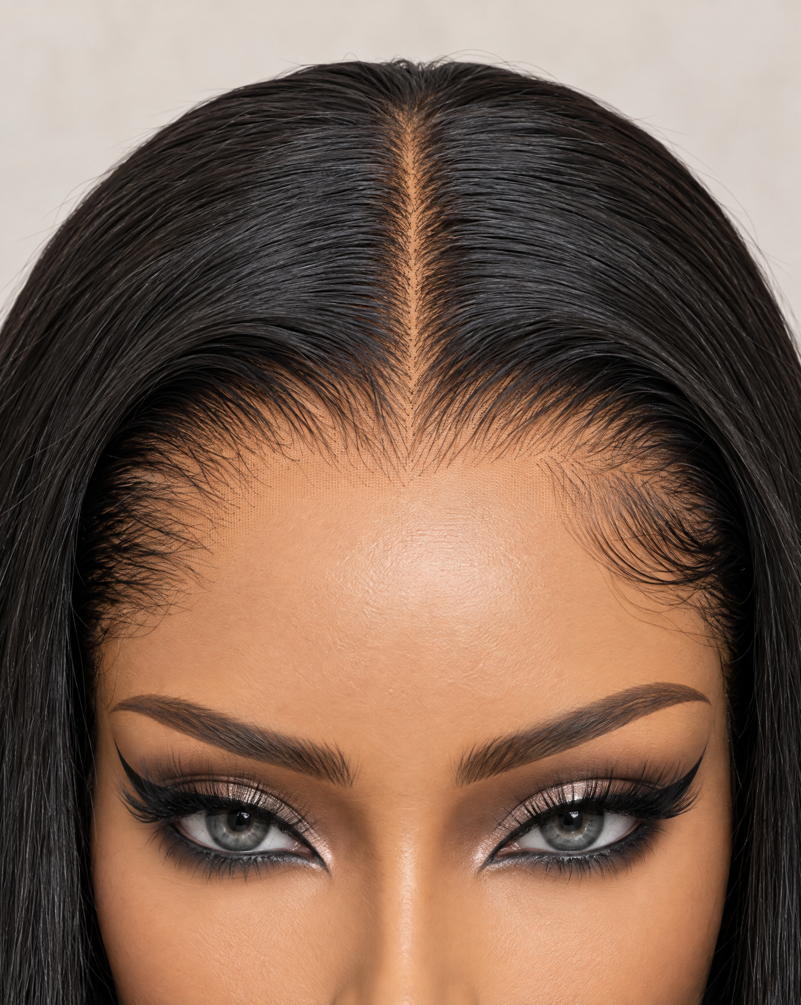 A close-up of a lace frontal wig with a clean center part and realistic hairline details.