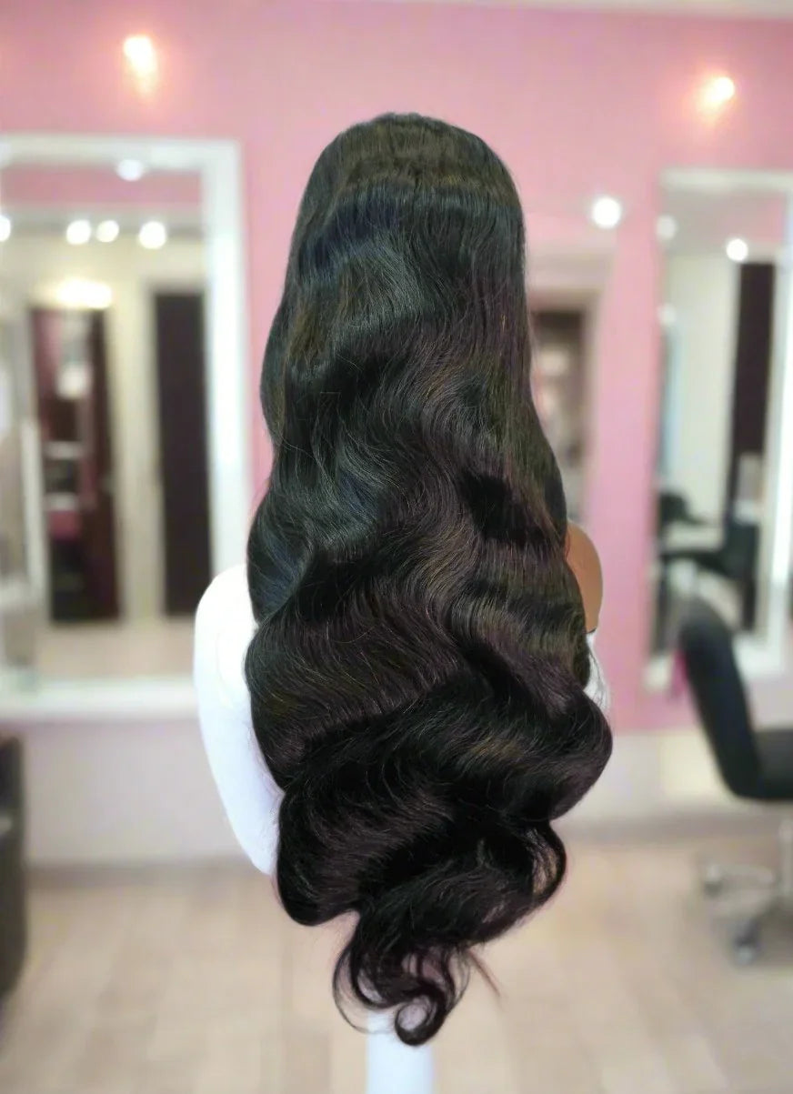 Long human hair wig with deep body waves displayed on mannequin in salon setting
