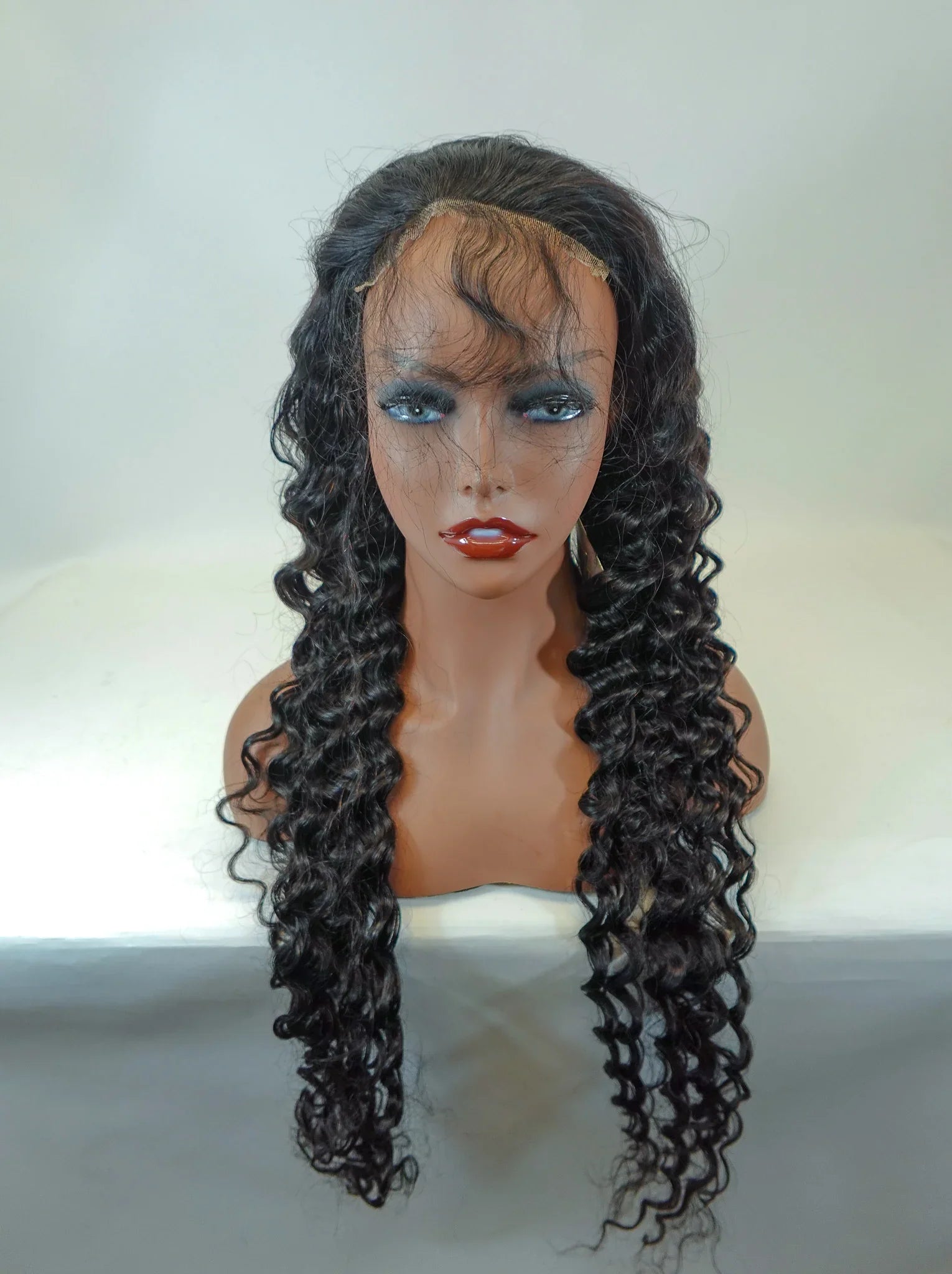 Long curly human hair wig with lace front on mannequin, natural styling for versatile looks