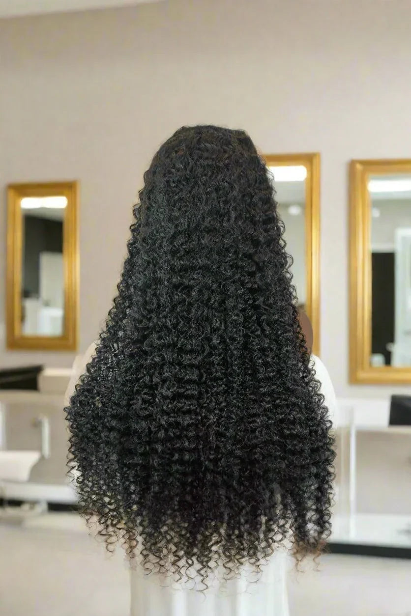 Long curly human hair wig with natural texture, styled in a salon setting