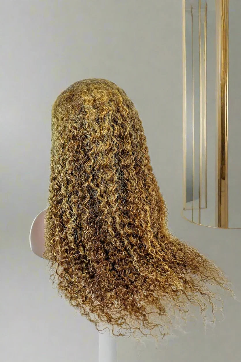 Long curly human hair wig with golden highlights on mannequin head