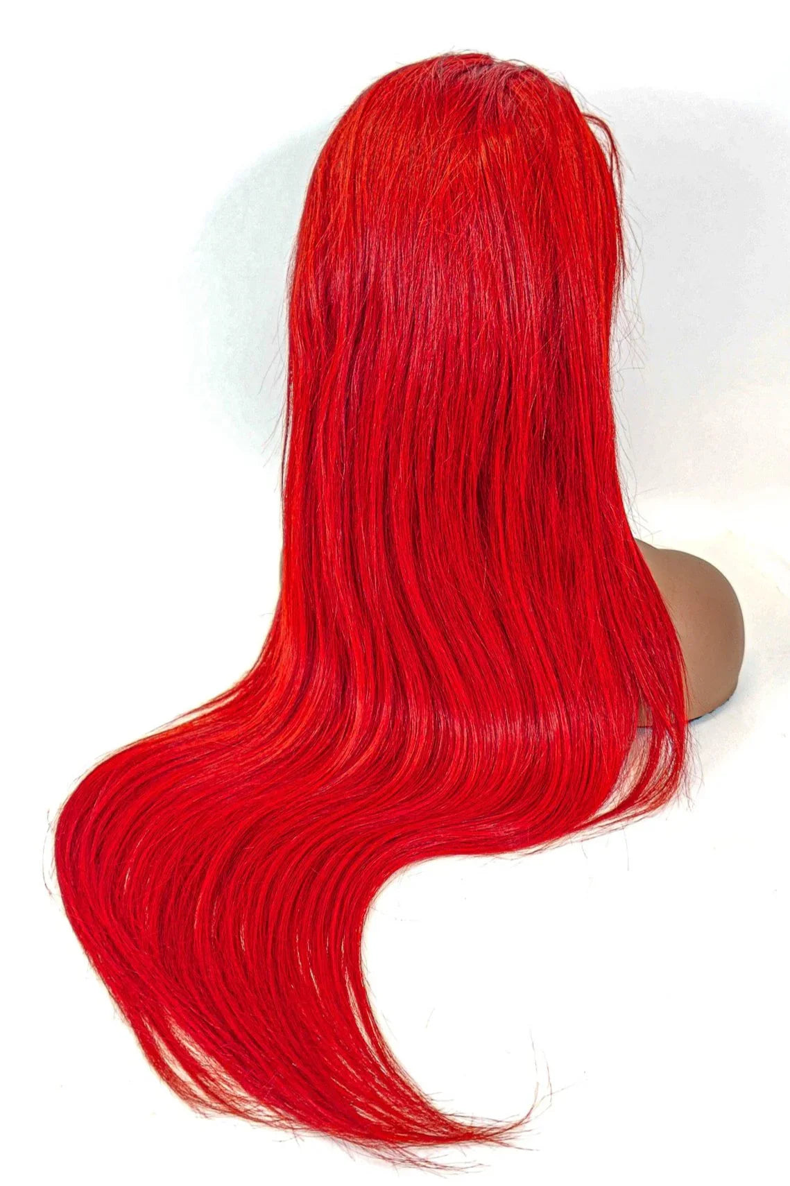 Vibrant red human hair wig with long, sleek waves on mannequin head