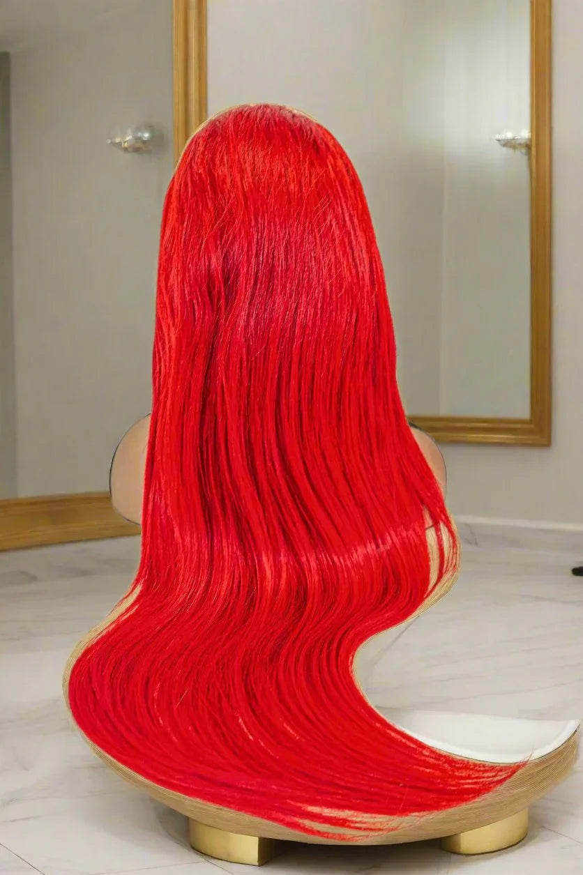 Vibrant red human hair wig with long, flowing waves displayed on mannequin head