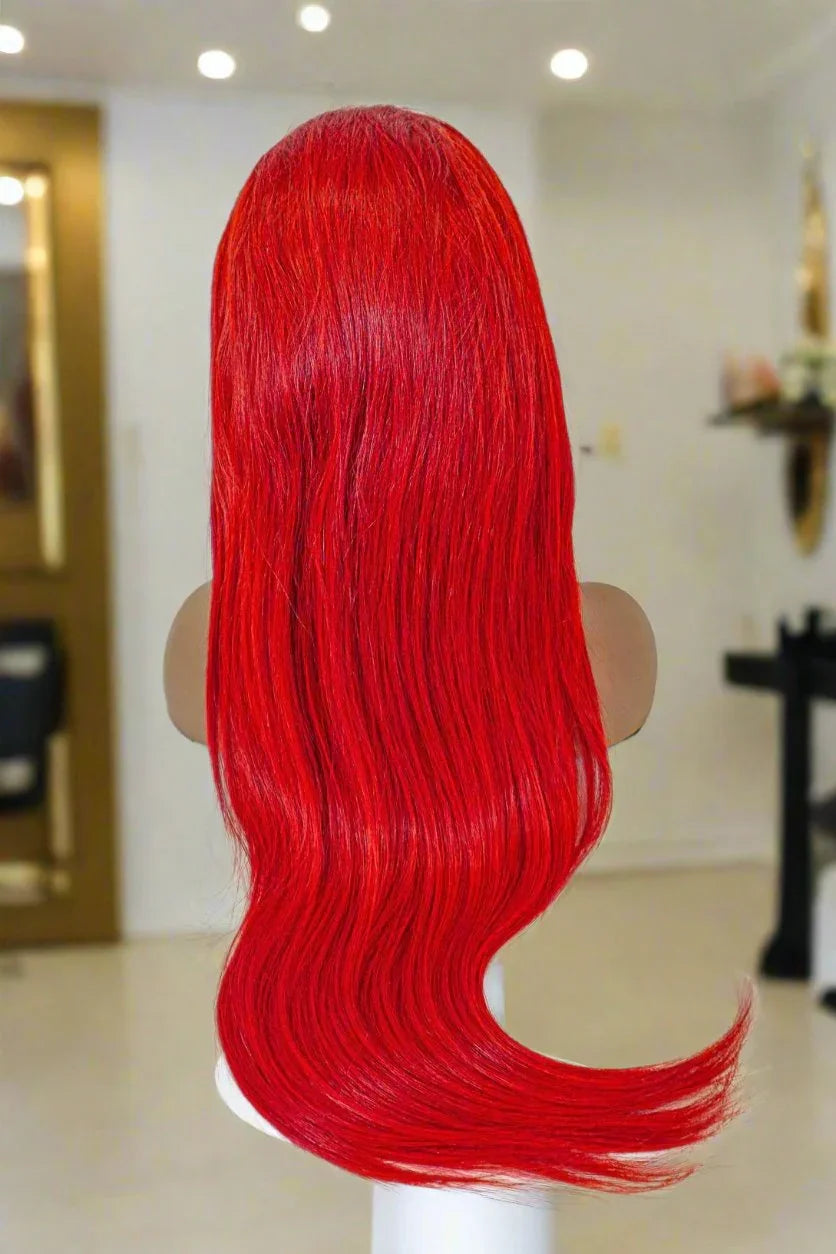 Vibrant red human hair wig with long body waves on mannequin, salon-style display