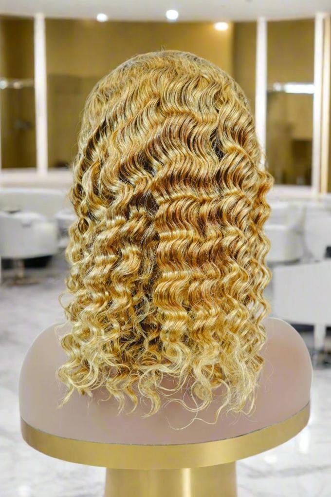 Blonde human hair wig with voluminous curls displayed on mannequin in salon setting
