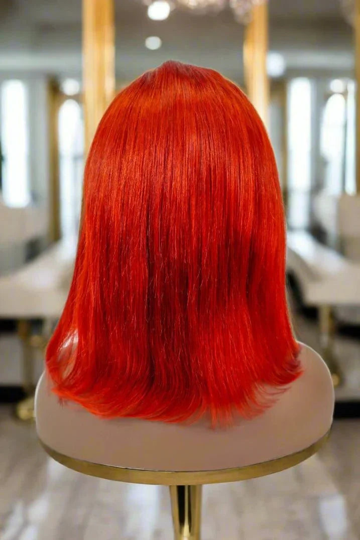 Vibrant red human hair wig on mannequin, sleek bob style for natural styling