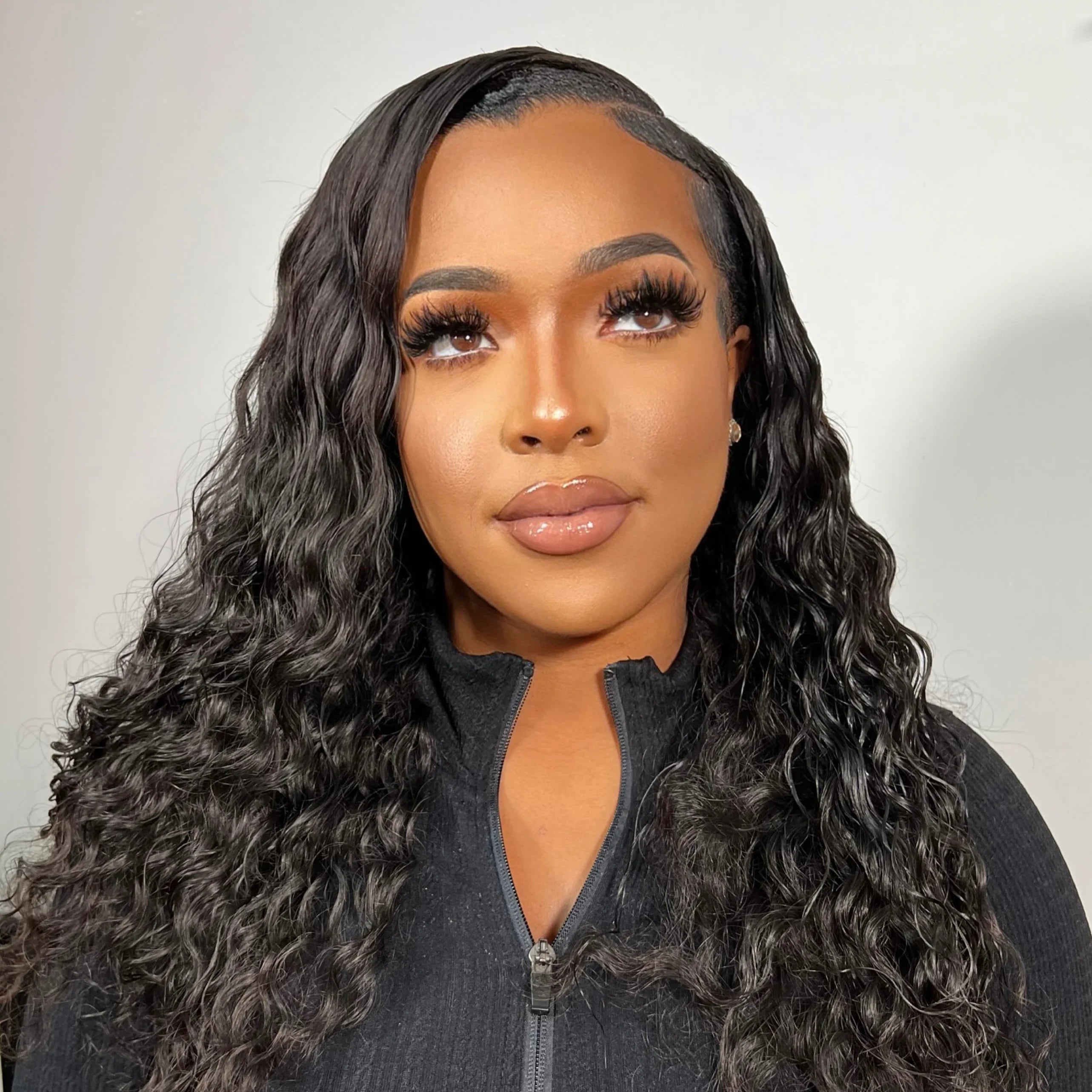 Woman wearing a natural-looking human hair wig with deep waves and a seamless lace front.