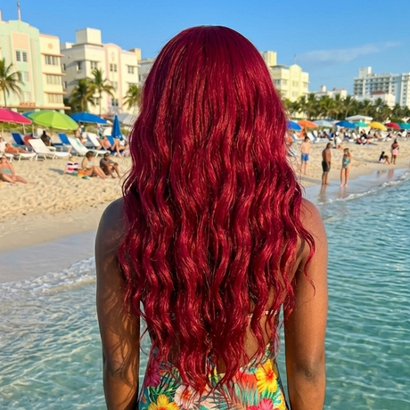 Person with red hair wearing a colorful swimsuit on a beach