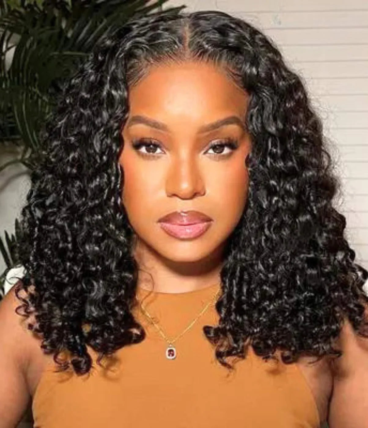 Woman wearing voluminous curly human hair wig with natural-looking lace front