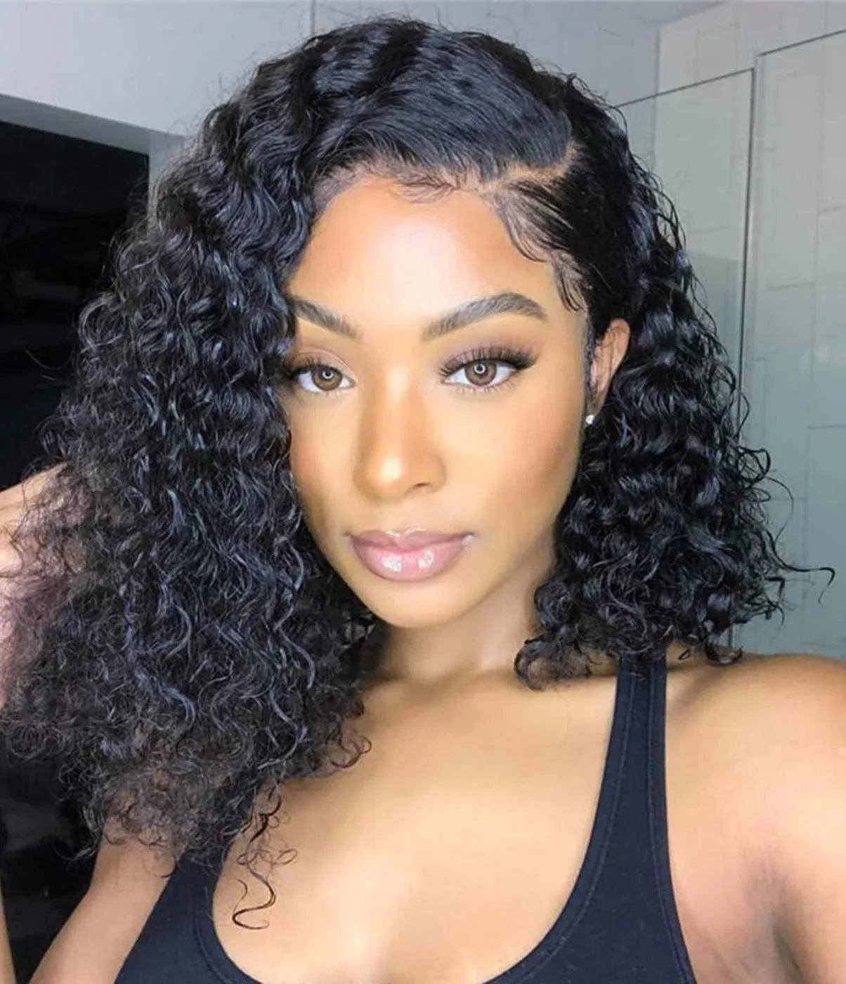 Black woman wearing a curly human hair wig with lace front, styled in voluminous waves for natural look