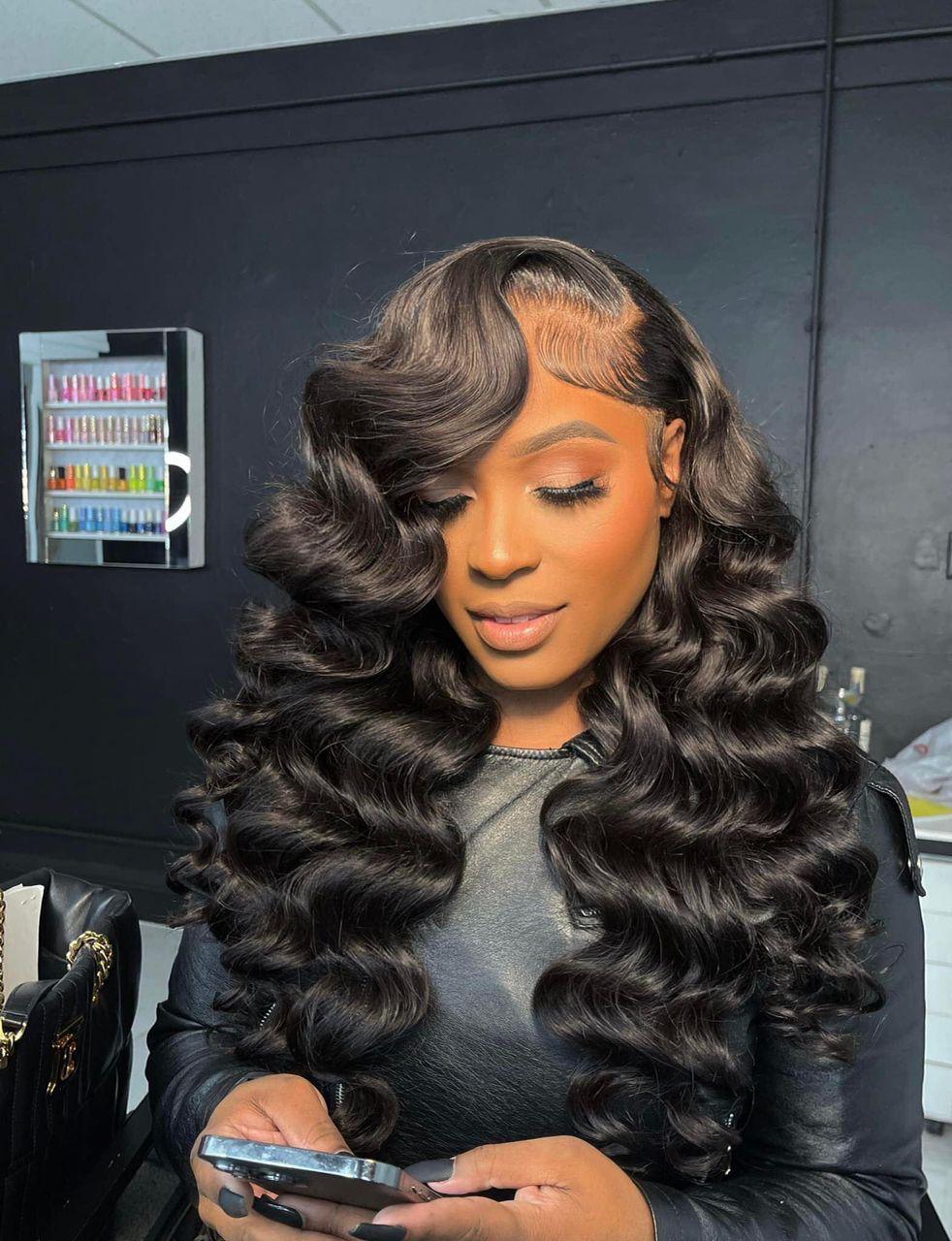 Woman with voluminous deep wave human hair wig, natural part, salon setting